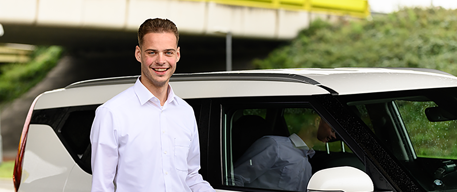 taxichauffeur naast witte taxi