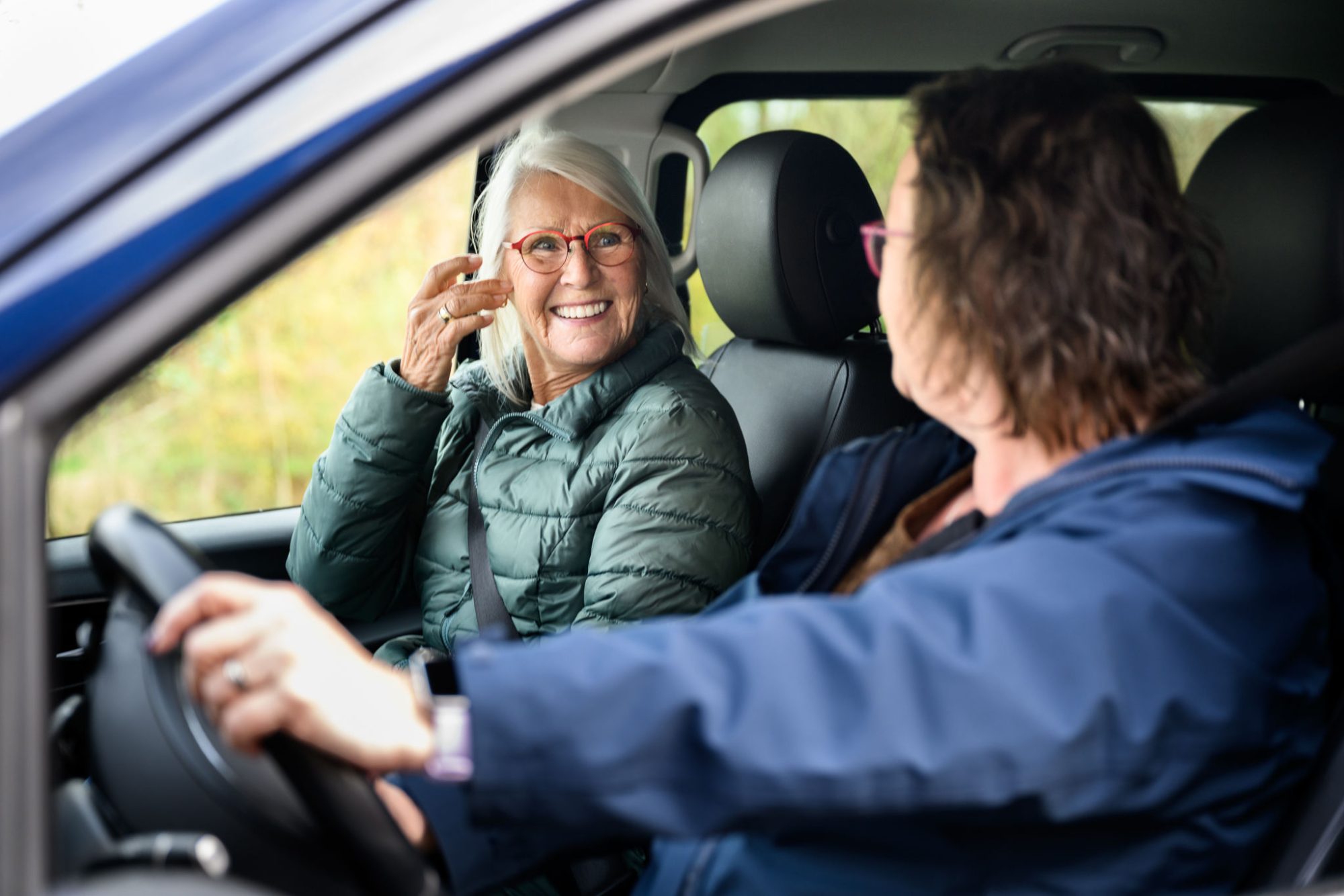 vrouwelijke chauffeur lacht naar passagier